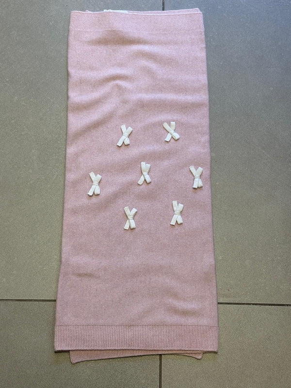 Coperta in lana rosa con fiocchetti panna