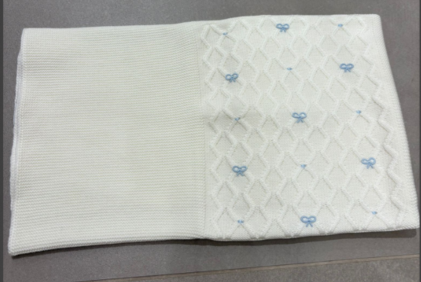 Coperta fondo panna con fiocchetti celesti in lana
